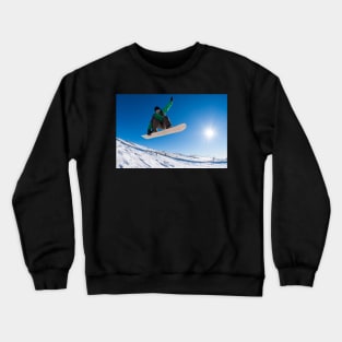 Snowboarder jumping against blue sky Crewneck Sweatshirt